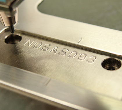 Image of serial numbers 'NOSASO93' engraved on steel
